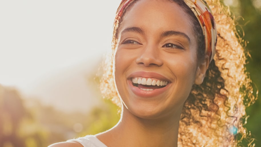 Person smiling with the sun in the background