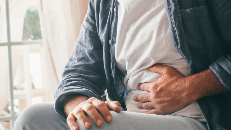 Patient suffering from gastroenterology disorder holding their stomach