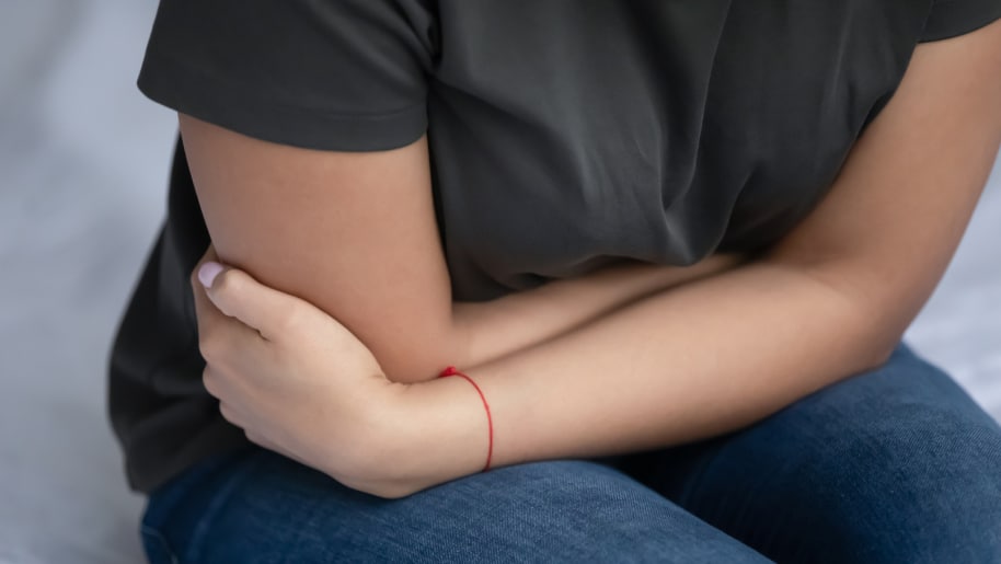 Patient suffering from gastroenterology disorder holding their stomach